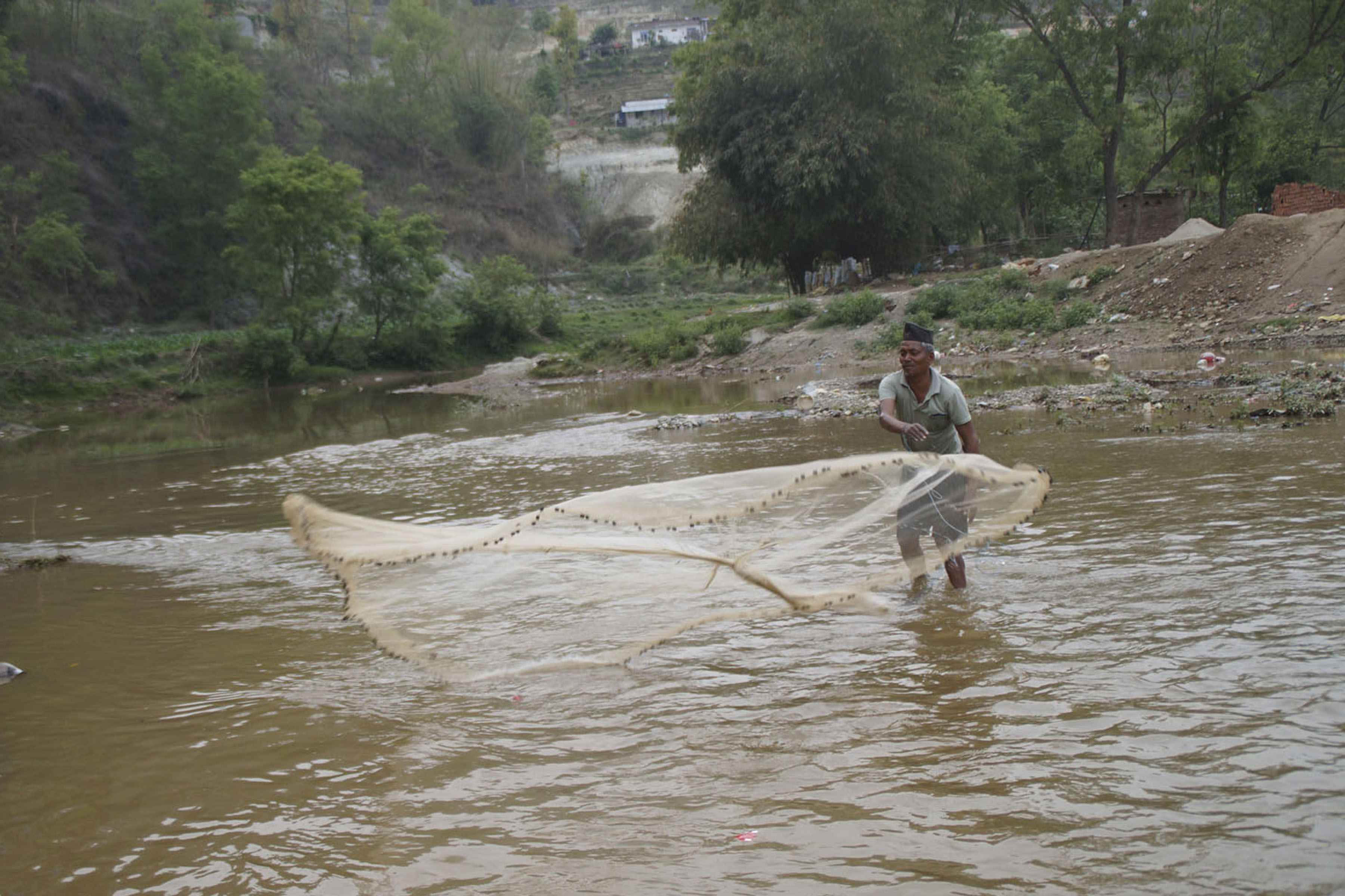 धादिङबेसीस्थित खोलामा माछा मार्दै माझी